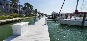 A marina dock with dock boxes and shore power pedestals and boats on the water.