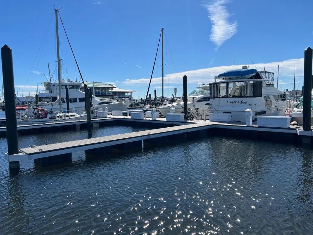 Landscape photo of a boat dock with large boats as part of a luxury marina.