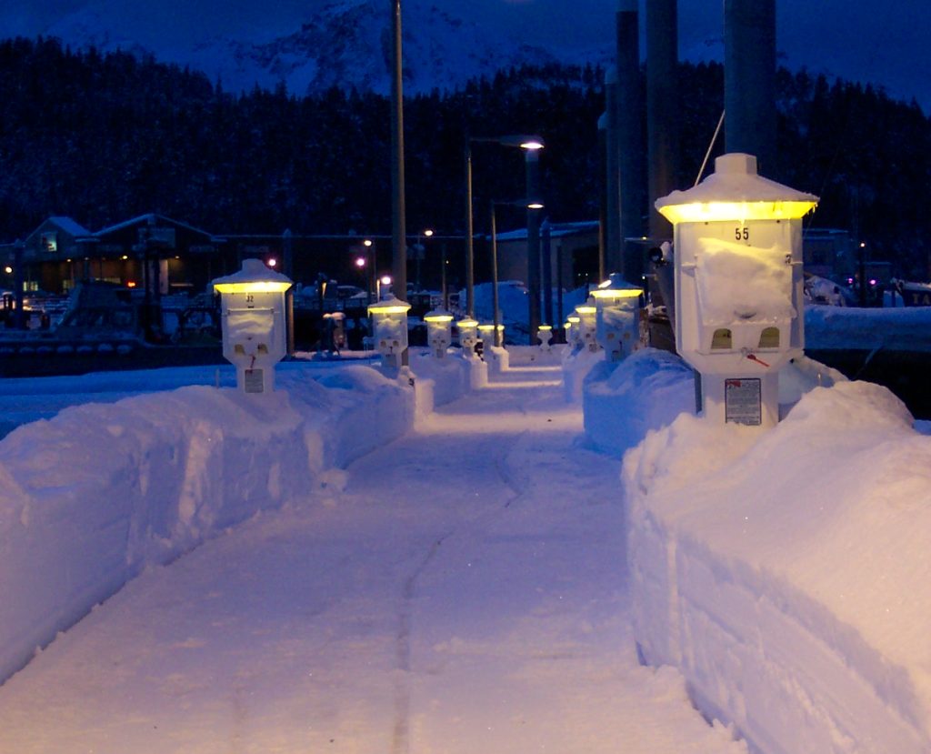 A snowy bridge in Alaska at night time lit up by Eaton power pedestals along the docks.